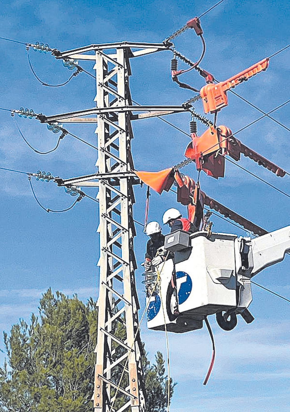 Operaris d’i-DE rectificant una torre elèctrica.