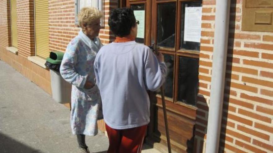 Dos vecinas de Milles dan lectura en la mañana de ayer en el edificio del Ayuntamiento a unos avisos municipales.