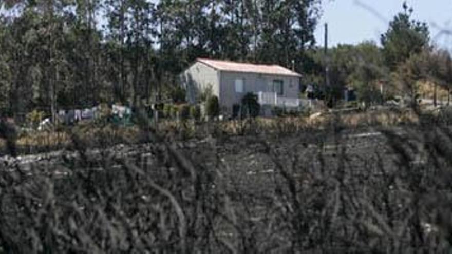 La casa de Josefa y Joaquín, rodeada de terreno calcinado tras el incendio que quemó el monte de Boiro y sitió su vivienda