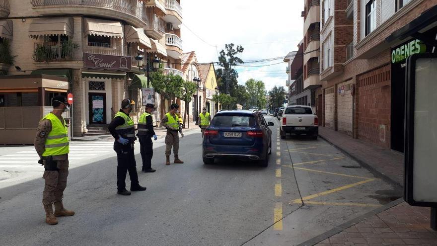 Agentes de la Policía Local y militares vigilan en una calle de Archena.