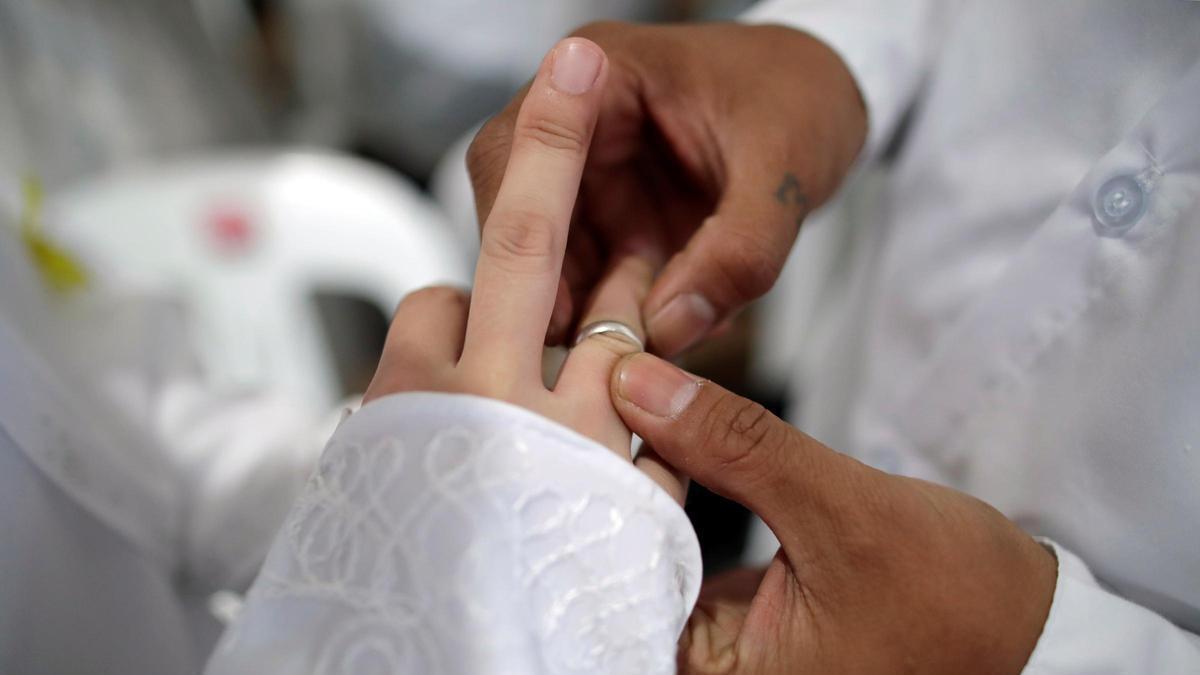 Un hombre coloca la alianza matrimonial a su futura esposa.