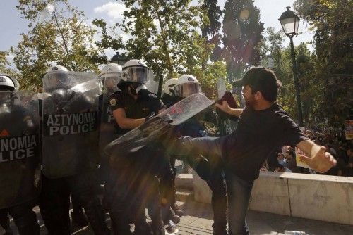 Demonstrator kicks riot police at a protest march by Greece's Communist party in central Athens during a 24-hour labour strike