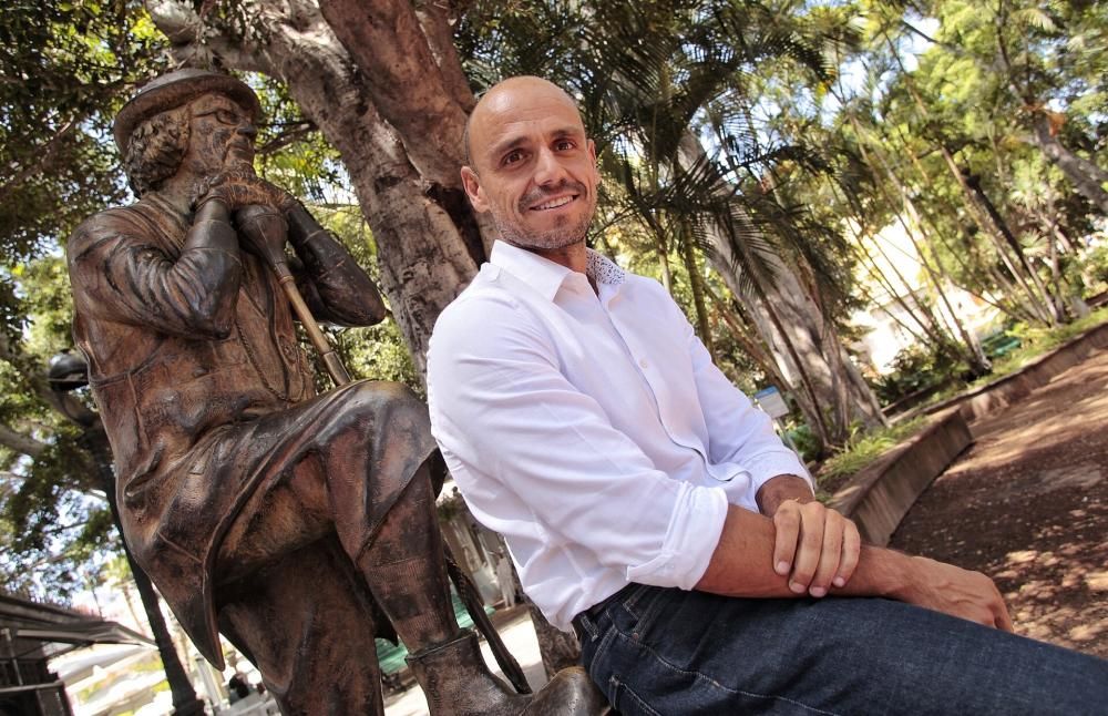 Alfonso Cabello posa junto a la estatua de Enrique González.