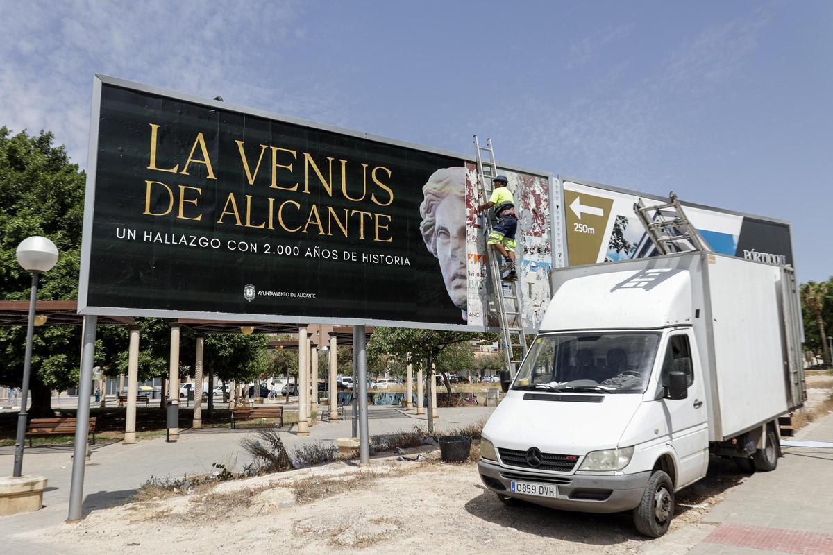 Operarios instalan un cartel publicitario sobre la Venus de Alicante, este mismo martes.