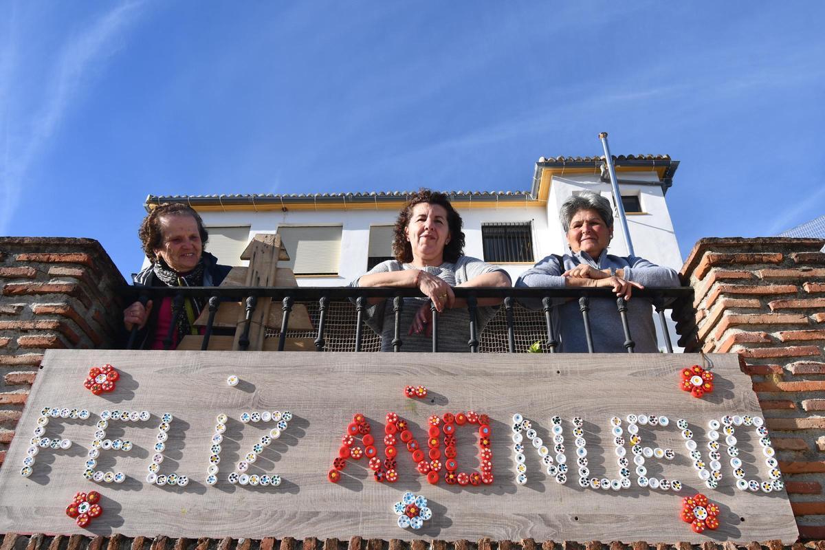 Tres vecinas de Algatocín, junto al cartel que felicita las Fiestas