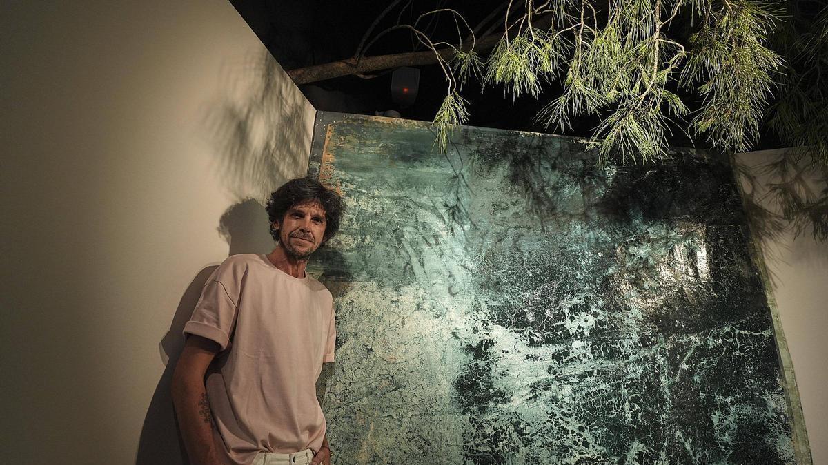 L'artista saltenc Joan Mateu amb una de les obres pictòriques de la mostra "Mar de Terra/Terra de Mar" a les Bernardes de Salt.