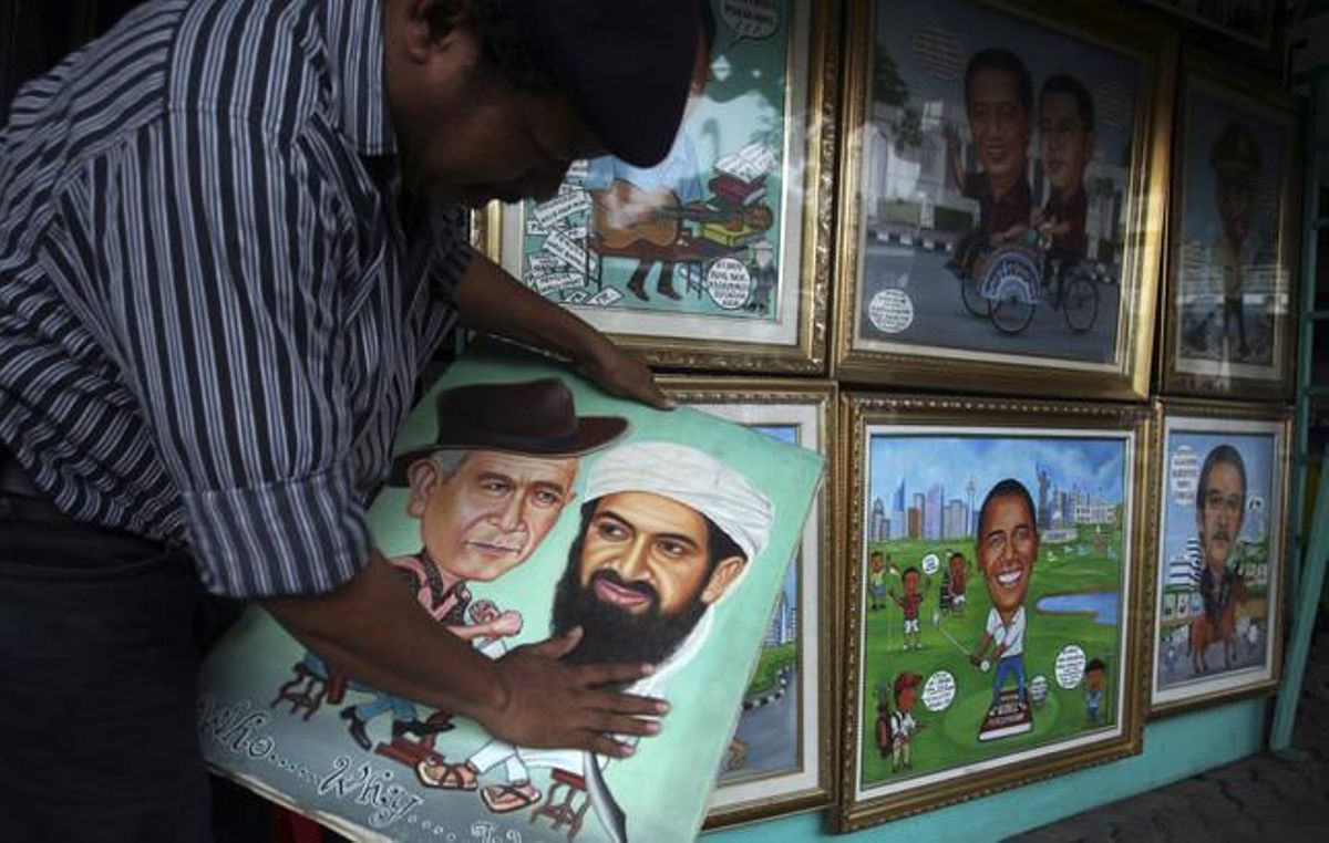 Un pintor indonesi mostra un retrat en què apareixen Ussama bin Laden i l’expresident dels Estats Units George W. Bush al seu estudi al carrer a Jakarta.