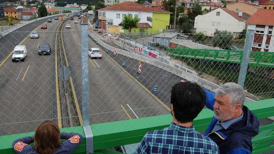 Miembros del ANPA y de la AVV de Chapela miran las obras junto al colegio, con el tercer carril aún cerrado.  // A.P.