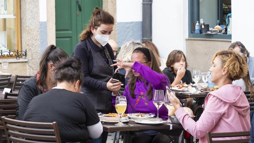 Varias personas en la terraza de un bar.