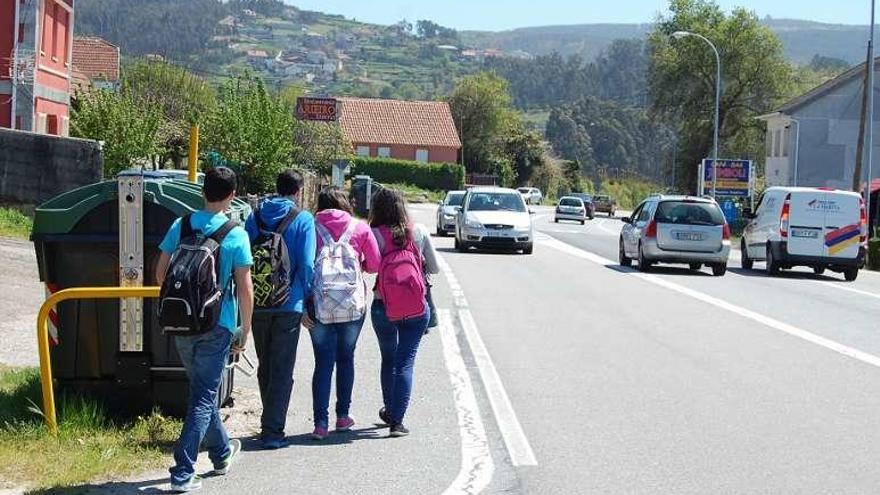 Unos peatones transitan por el arcén de la N-550 en Cesantes. // FdV