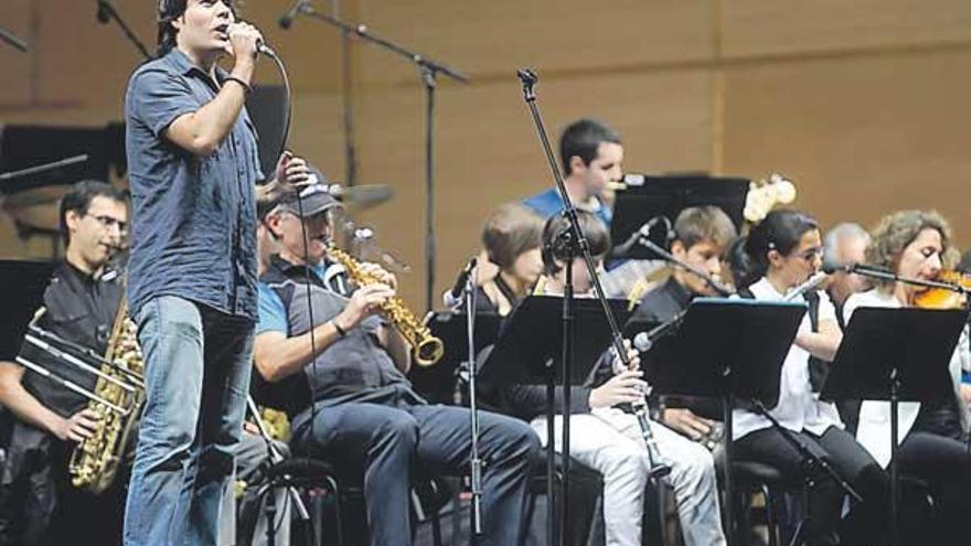 El cantante de la escuela, ayer, con sus compañeros instrumentistas de fondo, en María Pita. / juan varela