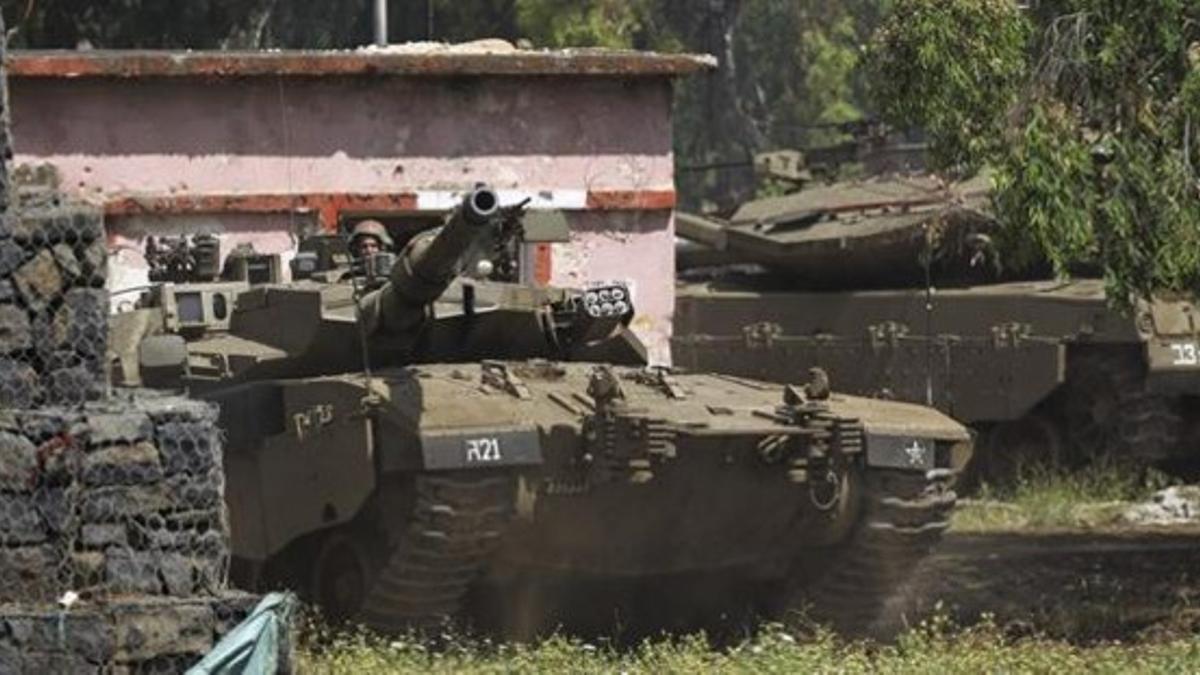 Tanques israelís participan en unas maniobras militares en los Altos del Golán, junto a la frontera con Siria, este lunes.