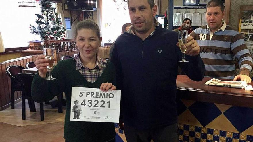 Paula García y Pablo Fernández, brindando por el quinto premio. Detrás Jesús García.