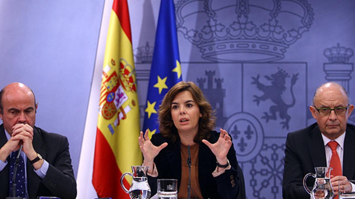 Luis de Guindos, Soraya Sáenz de Santamaría y Cristóbal Montoro, en una rueda de prensa posterior al Consejo de Ministros, el pasado marzo.