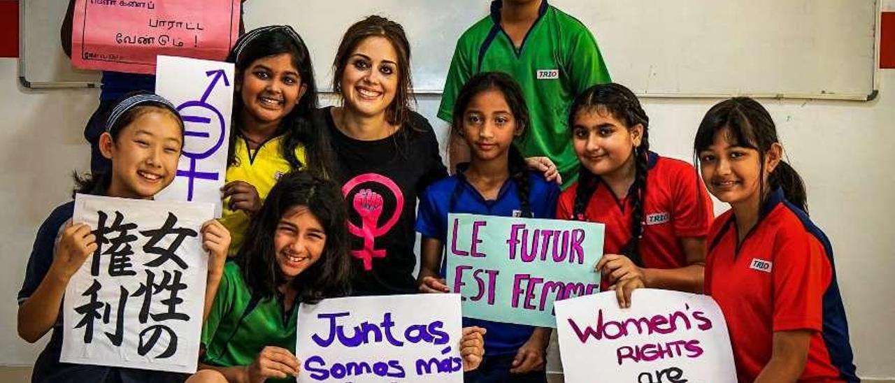 La profesora asturiana Sara Mañanes, en el centro, junto a sus alumnos de Bangalore (India), que muestran mensajes en diferentes idiomas a favor de la lucha feminista.