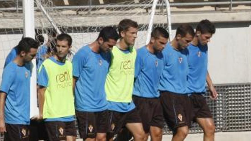 Varios jugadores del Real Murcia trasladan una portería durante un entrenamiento.