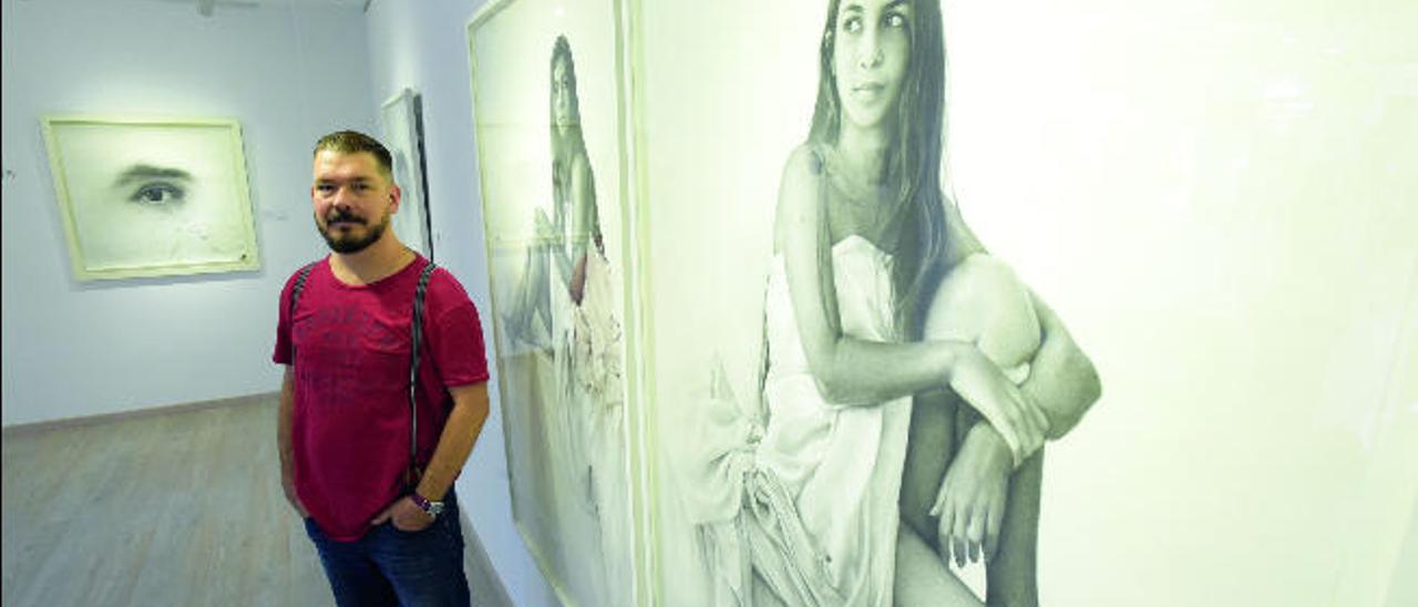 Víctor Ezquerro Barrera junto a dos de sus dibujos exhibidos en la sala de exposiciones  de La Molina Artesanía, en Las Palmas de Gran Canaria.