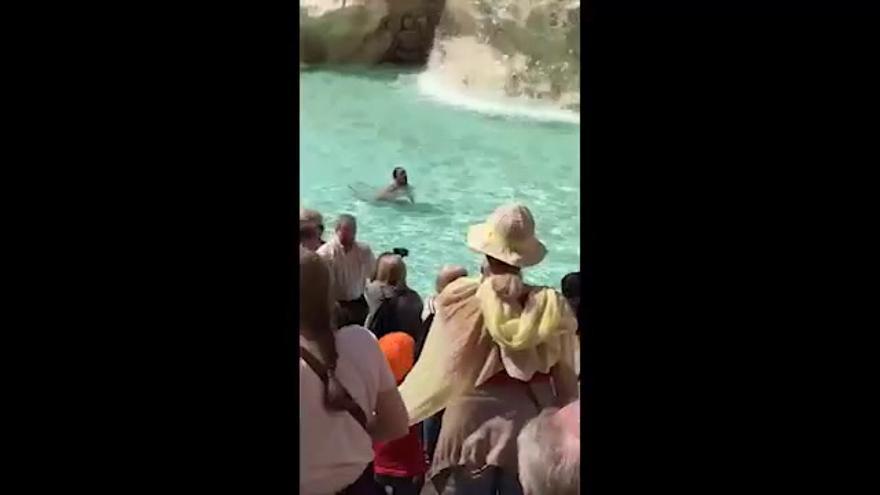 Un hombre nada desnudo en la Fontana de Trevi de Roma