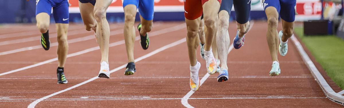 Atletas cruzan la línea de meta en una competición internacional.