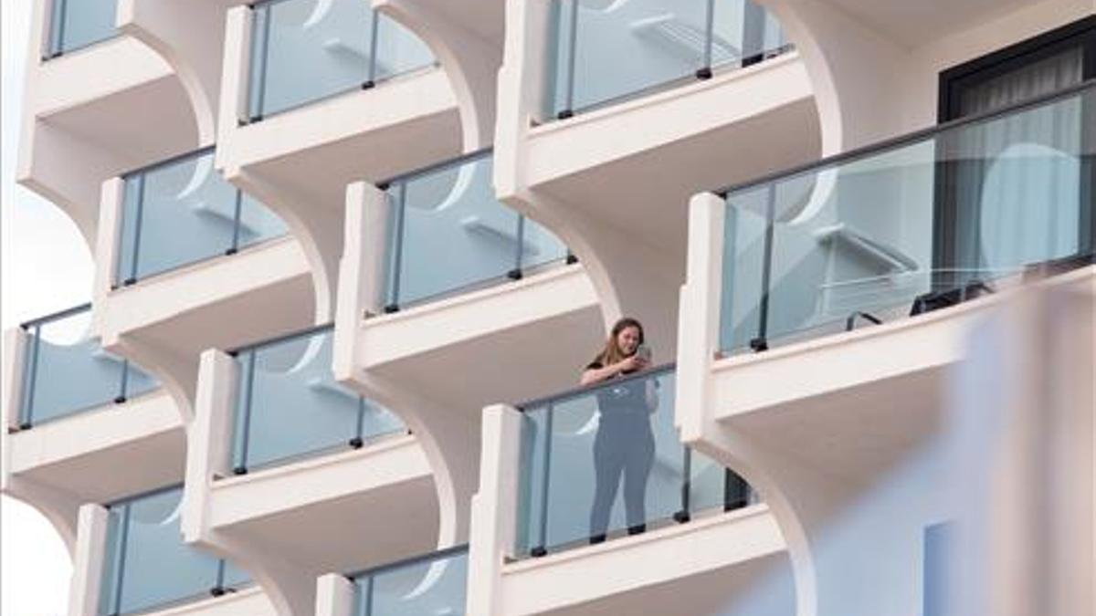 Una turista en el balcón de un hotel en la playa de Palma.