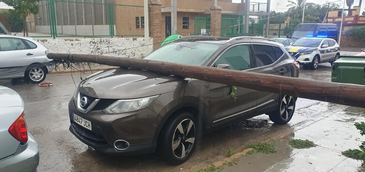 Un poste de teléfonos caído sobre un coche en Llíria por las fuertes rachas de viento de la tormenta de ayer.
