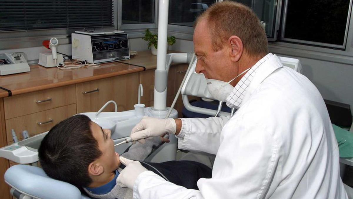 Un dentista atén un nen en una fotografia d’arxiu. | DIARI DE GIRONA