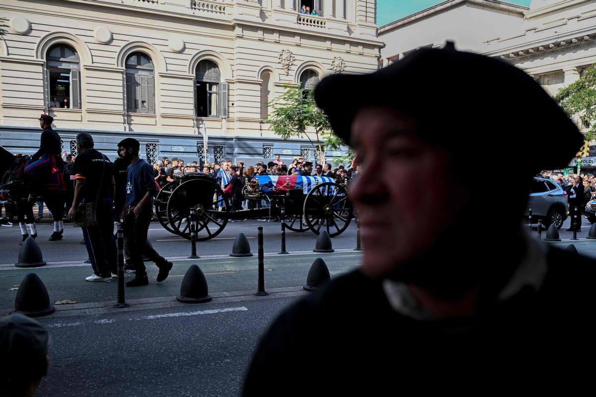 The funeral cortege of Uruguays former President Jose Pepe Mujica makes its way in downtown Montevideo, on May 14, 2025, a day after his death. Mujica, an ex-guerrilla fighter and hero of the Latin American left, died on May 13, 2025 at the age of 89. The humble leader -- who once spent a dozen years behind bars for revolutionary activity -- lost his battle against cancer after announcing in January the disease had spread and he would stop treatment. (Photo by Eitan ABRAMOVICH / AFP)