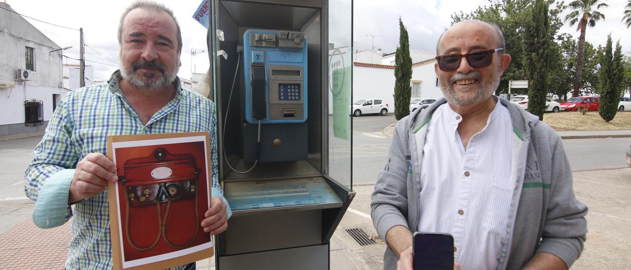 Fernando Sánchez-Arjona muestra el teléfono de su tatarabuelo y Fernando González su móvil, junto a una cabina telefónica.