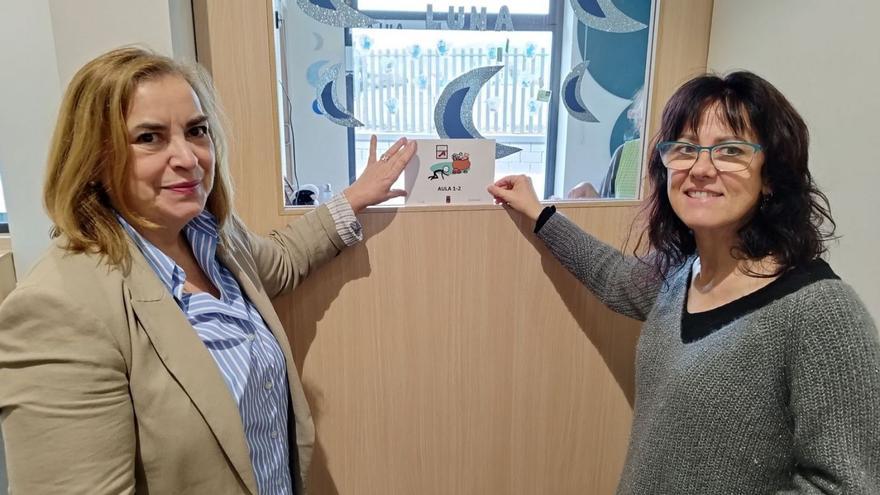 Por la izquierda, la edil Montse Alonso y la directora de la escuelina de Lugo, Susana de Íscar, con un pictograma instalado en el centro. | A. LL.