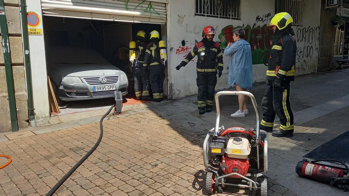 Los Bomberos informan a la dueña del almacén en la Rúa Nova de Arriba.