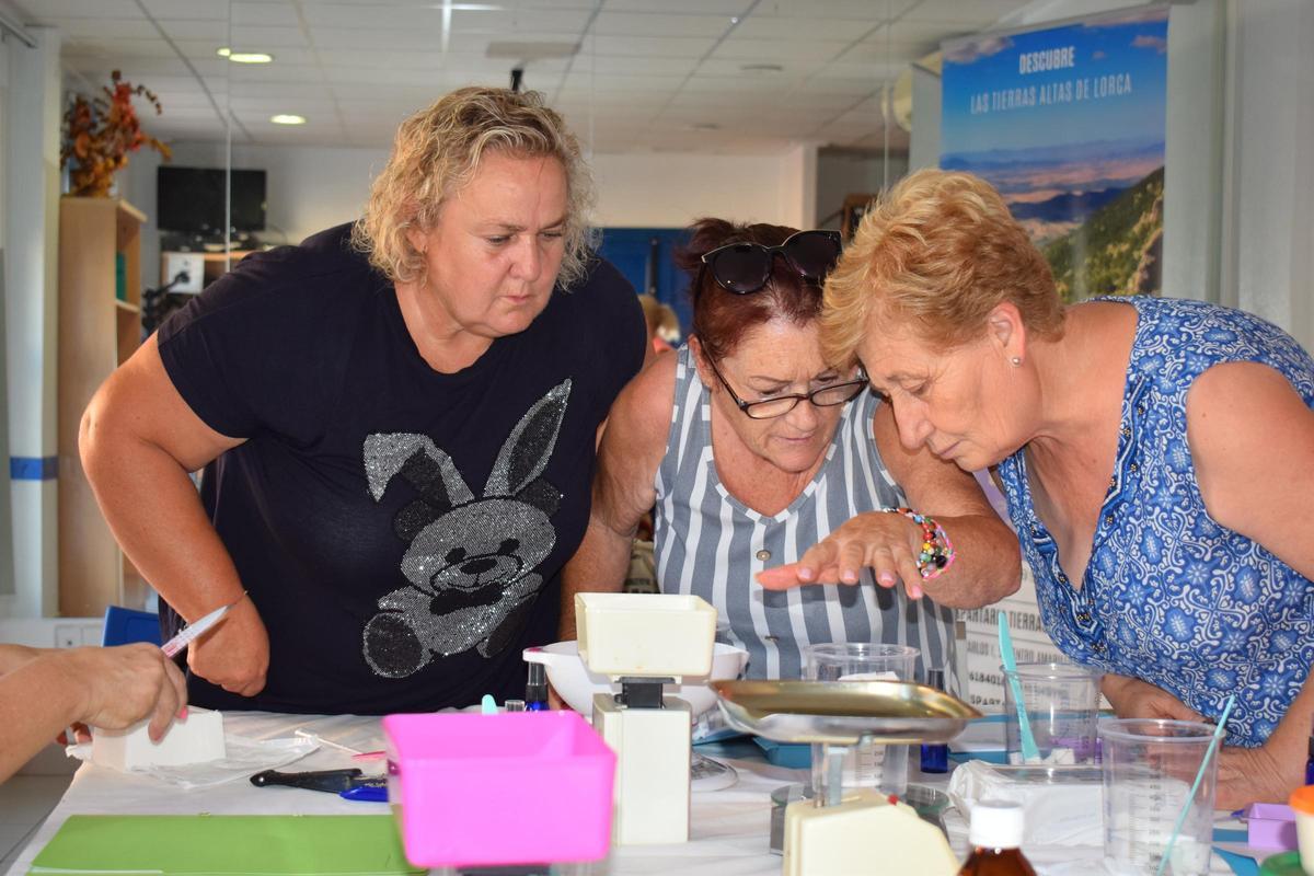 Algunas de las participantes del taller haciendo las mediciones correspondientes para elaborar los jabones.