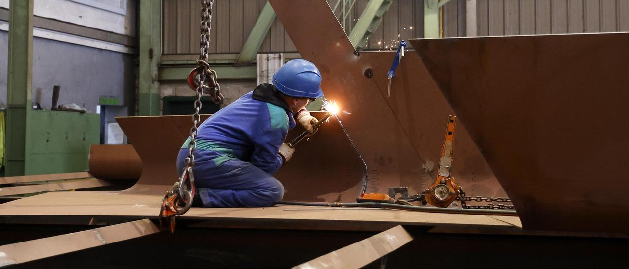 Un trabajador de un astillero de las Rías Baixas trabajando en el casco de un pesquero