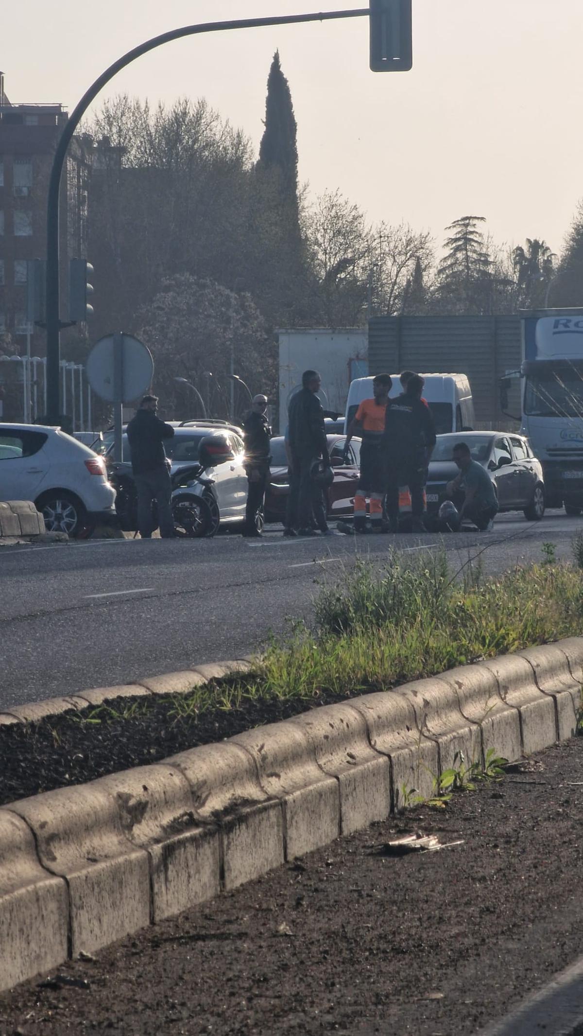 Sanitarios del 061 atienden al motorista herido, en el suelo.