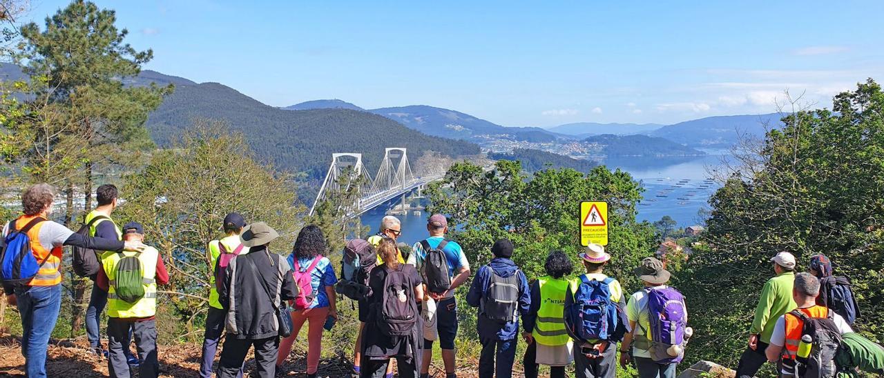 La veintena de miembros de Alcóholicos Anónimos, ante el puente de Rande durante su primera etapa del Camino.   | // MARTA G. BREA