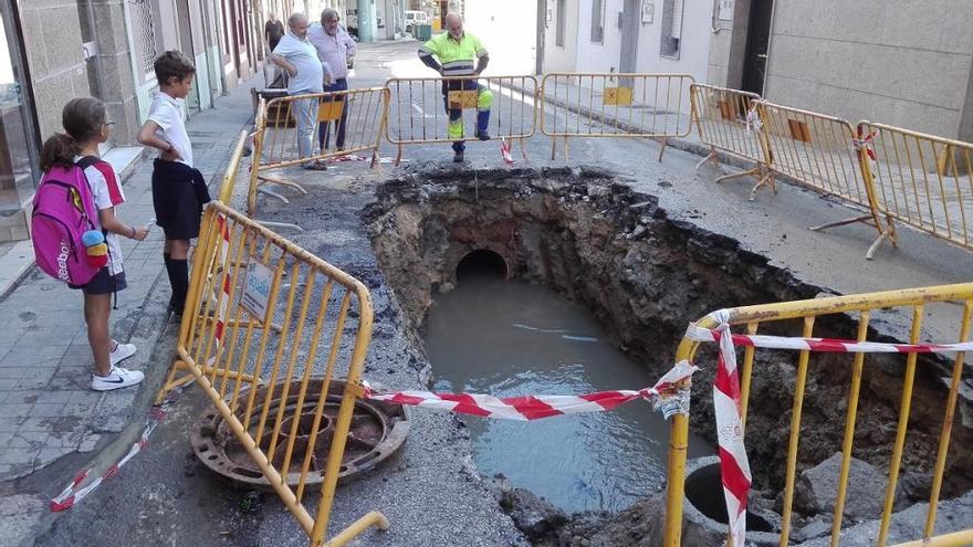 La avería en la red de alcantarillado obligó a abrir un gran boquete en la calle Santa Trega. / A.P.