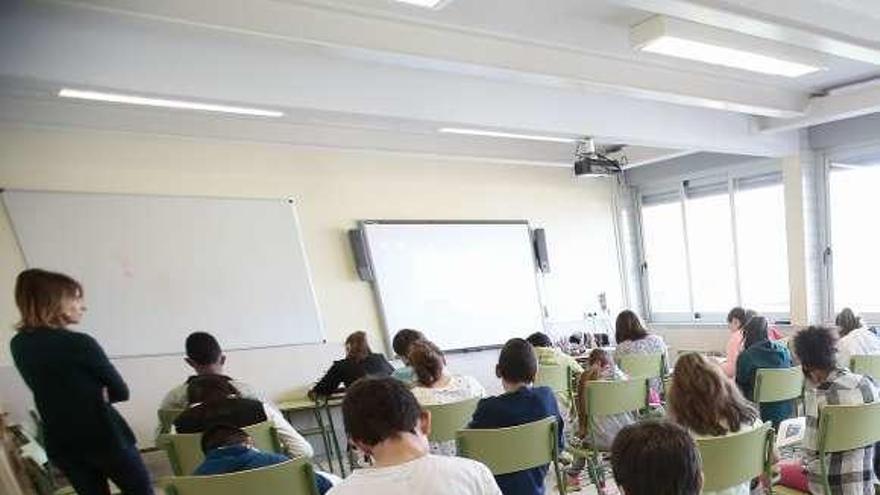 Una profesora vigila a alumnos de Primaria durante un examen.