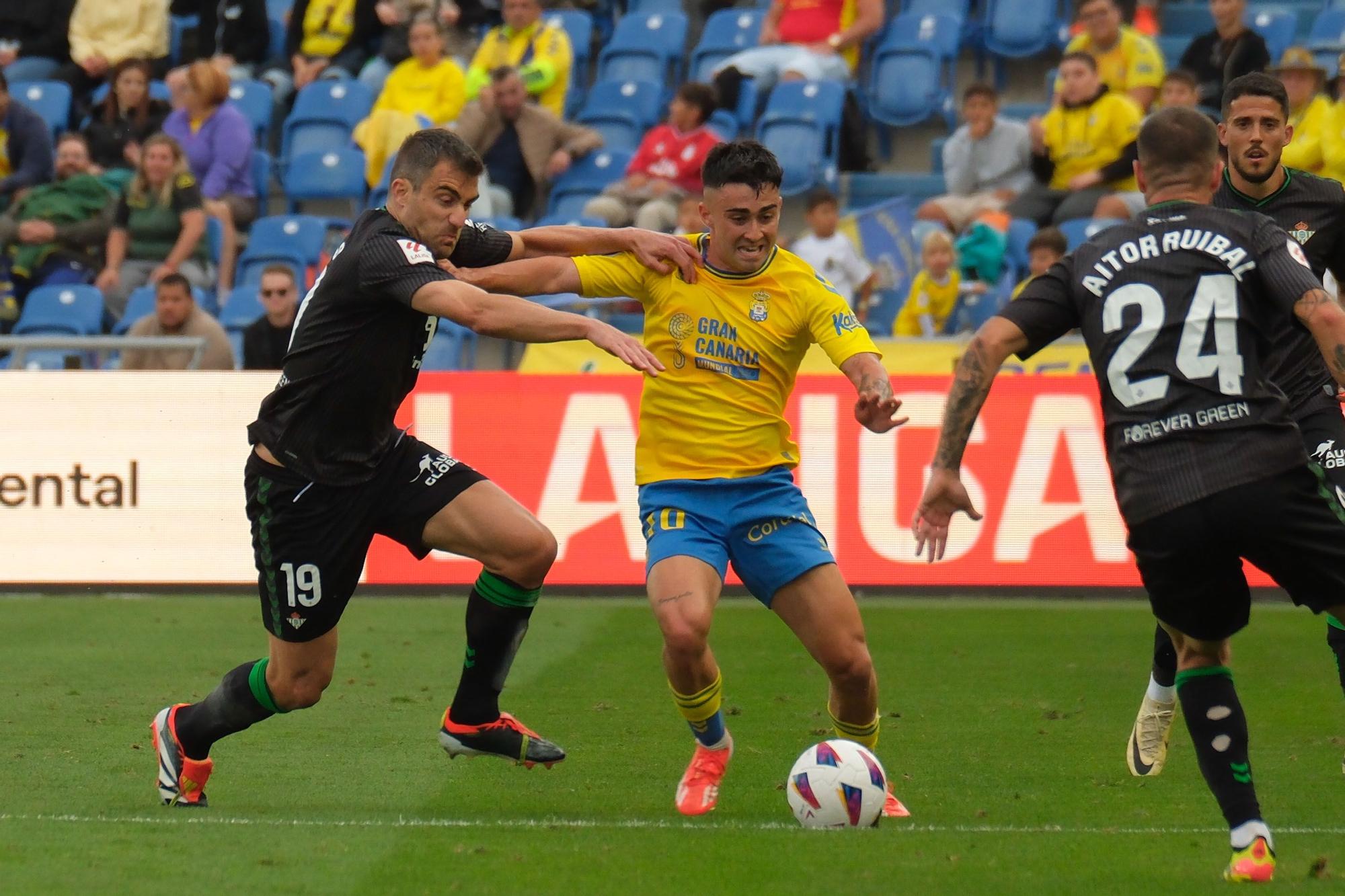 LAS PALMAS DE GRAN CANARIA, 16/05/2024.- El centrocampista de Las Palmas Alberto Moleiro (c) disputa un balón con el defensa del Betis Sokratis Papastathopoulos (i) durante el encuentro correspondiente a la jornada 36 de LaLiga entre U.D. Las Palmas y Real Betis Balompié, este jueves en el Estadio de Gran Canaria. EFE/ Ángel Medina G