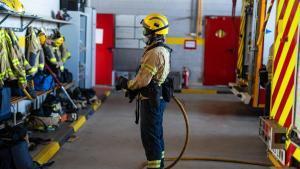 Rubí (Barcelona). Un bombero de línea posa con una manguera y el equipo de intervención utilizado en incendios urbanos durante un reportaje sobre los distintos perfiles operativos de los Bombers de la Generalitat, en el parque de bomberos de Rubí. 5 de agosto de 2026. Sociedad. AUTOR: ZOWY VOETEN
