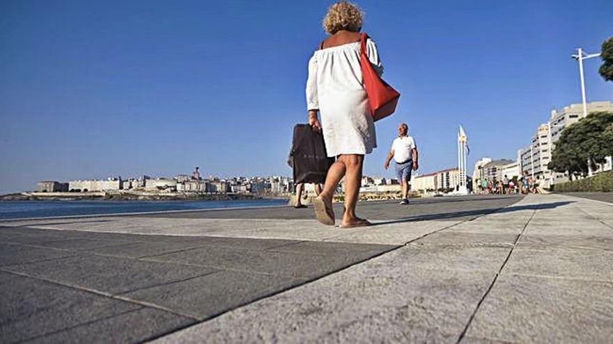 Personas paseando por el paseo marítimo en la zona de Riazor.