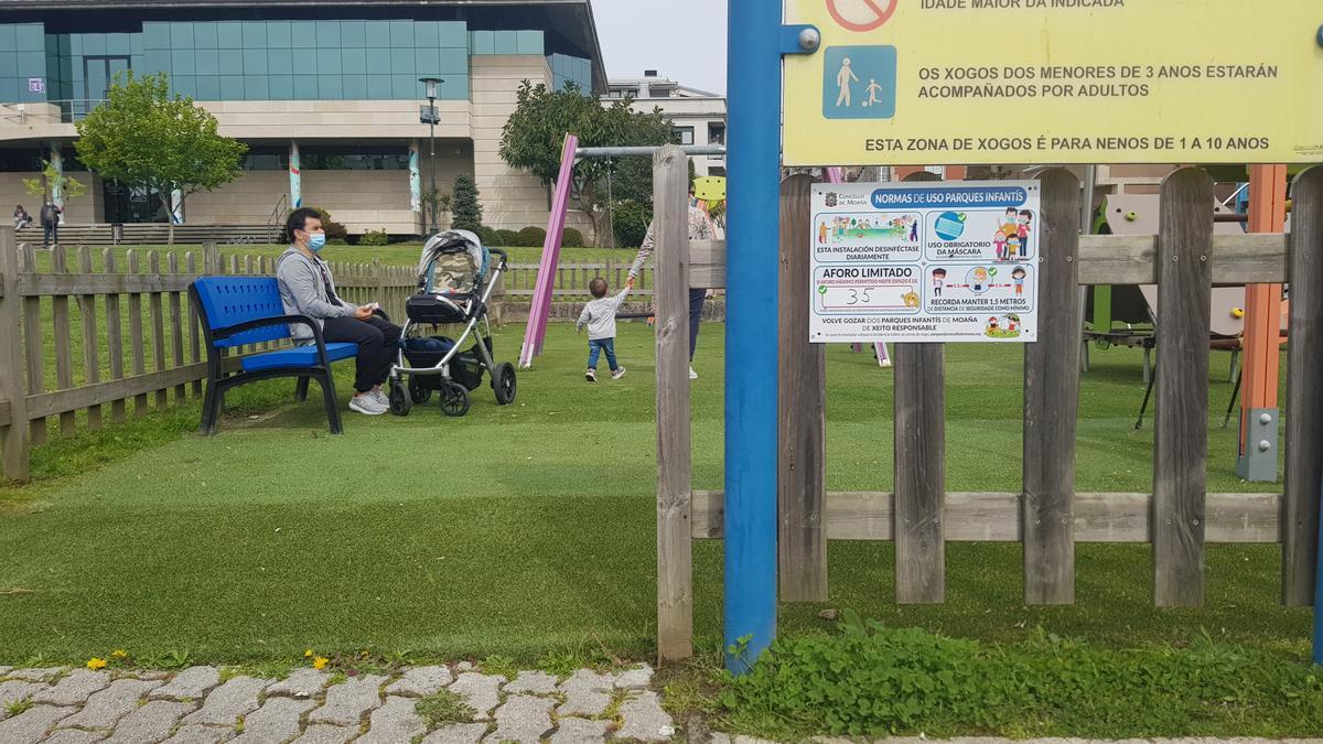 Una familia, esta mañana, con su hijo en el parque del Concello. / F.G.S.