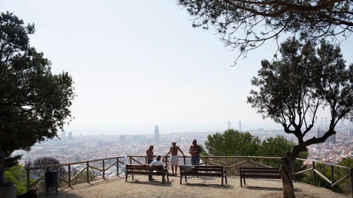 Varias personas hablan distendidamente en un mirador de la ciudad.