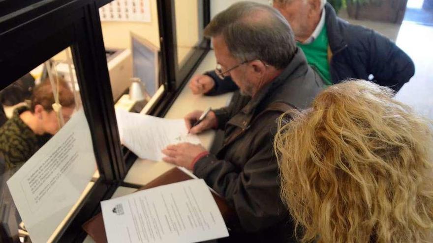 Miembros de la PAH presentan su escrito en el registro del Ayuntamiento.