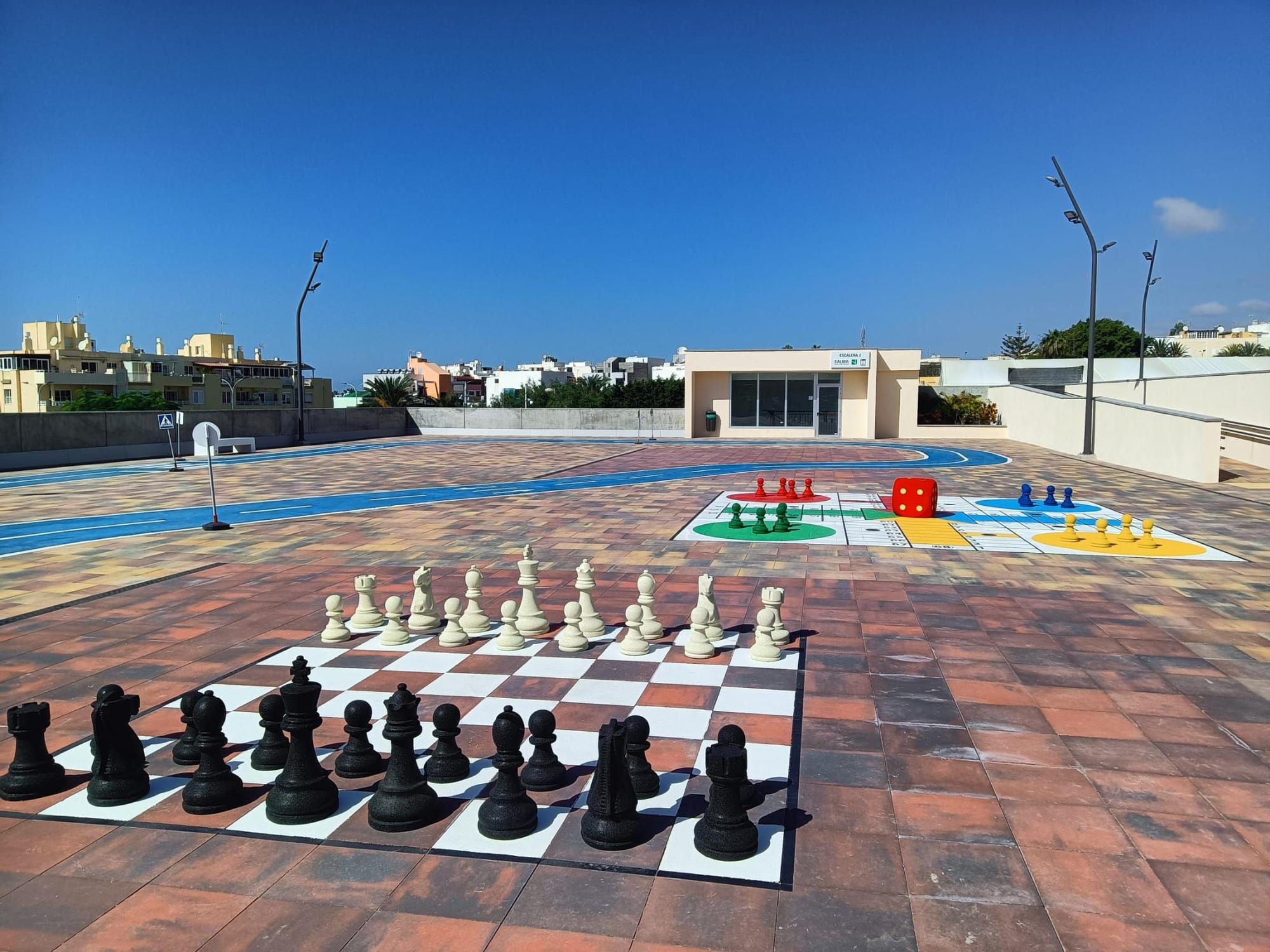 Plaza pública ubicada sobre el edificio de aparcamientos con juegos infantiles.