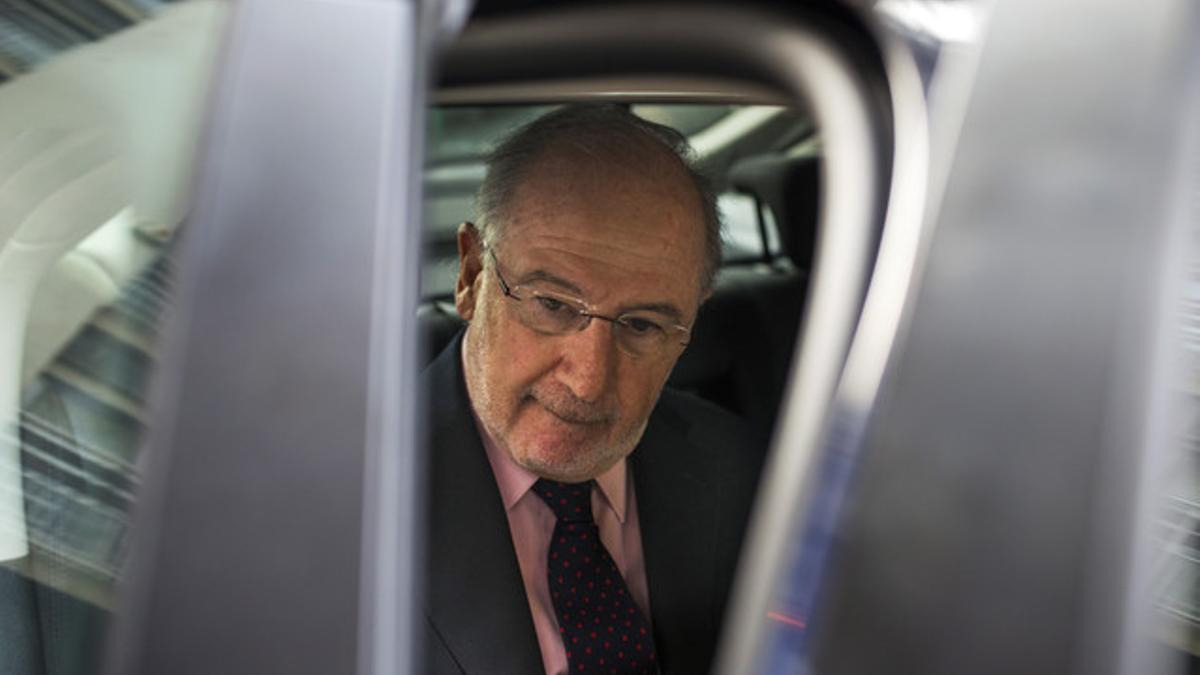 Rodrigo Rato entra en el coche tras un registro policial en su vivienda, el pasado abril en Madrid.