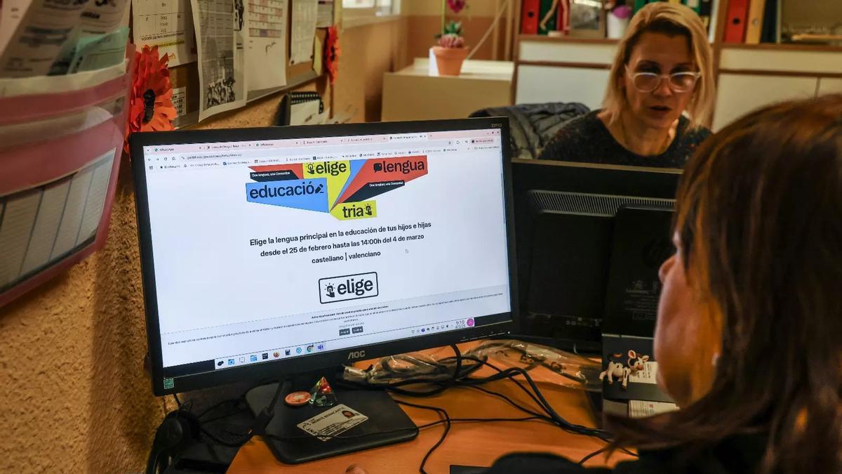 Familias votando en la consulta de la lengua en un centro de Alicante.
