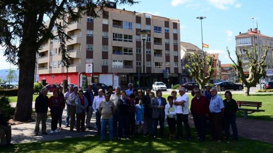 Un grupo de una treintena de afectados por la ley de Costas con el edificio Salitre al fondo, uno de los emblemas de la lucha contra la normativa de 1988.  // G.Núñez