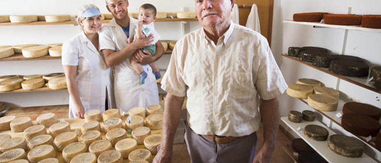 Los queseros Yurena y Daniel Rodríguez con su pequeño, en la Quesería La Casita, y delante el abuelo y patriarca, Juan Vera, creador de la industria de Vallebrón.