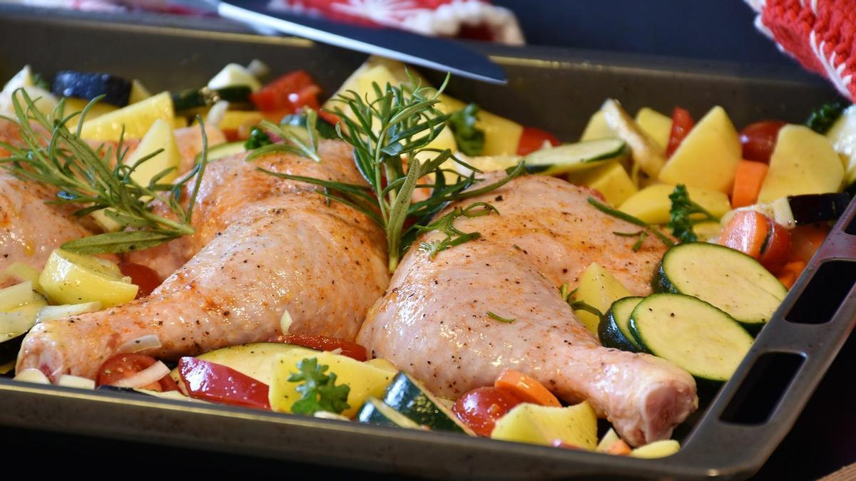 Una bandeja de horno con pollo y vegetales