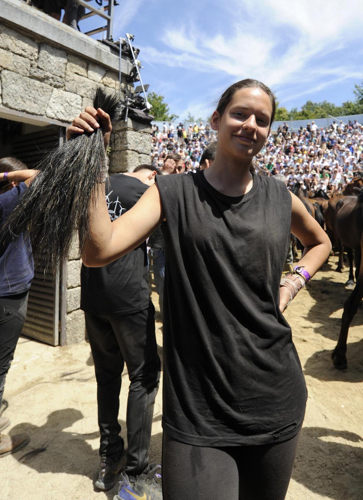 Noa González posa coas crins dunha egua. Rapa das Bestas 2024. Bernabé / Javier Lalín