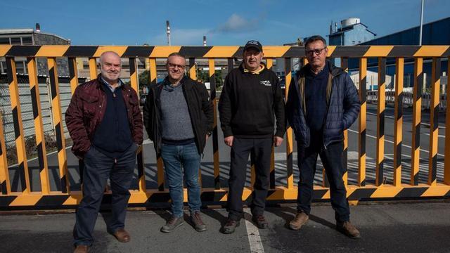 Cuatro empleados de Alu Ibérica, ayer a las puertas de la fábrica. | // CASTELEIRO/ROLLER AGENCIA